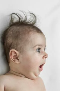 A baby boy looking off camera with an expression of surprise Stock Photos