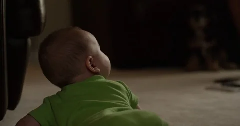 Baby boy looking up from carpeted floor Stock Footage