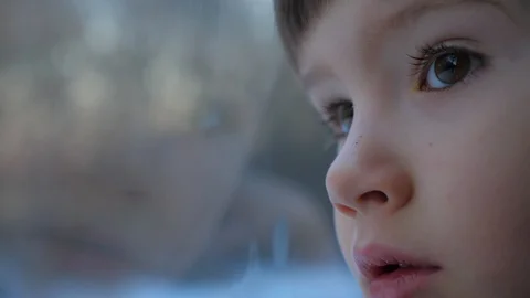 Baby boy looking through window. Kid travels on a train. Teen's face close-up Stock Footage 104268539
