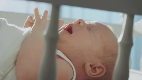 Baby boy lying in crib 스톡 동영상 234332256