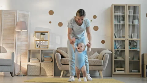 Baby Boy Making First Steps with Mother Help Stock Footage 142202176
