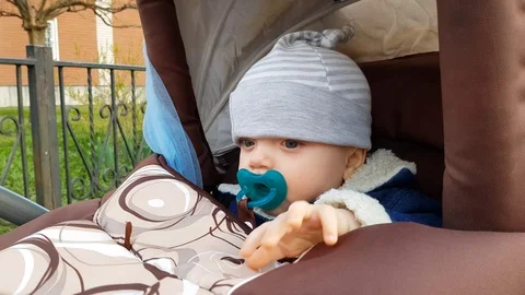 Baby boy with pacifier in stroller Stock Footage 102324351