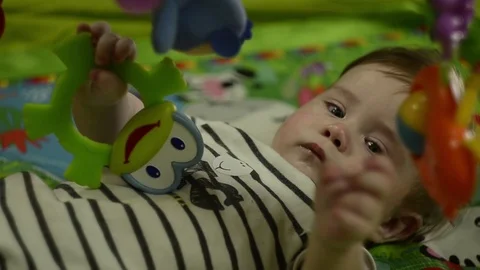 The baby boy is playing with a plastic frog Stock Footage 114967910