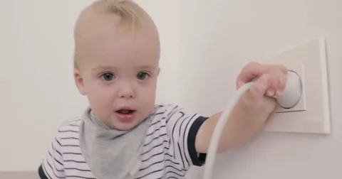 Baby boy playing with plug and socket Stock Footage 80415097