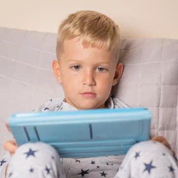 Baby boy playing using digital tablet Стоковые фото