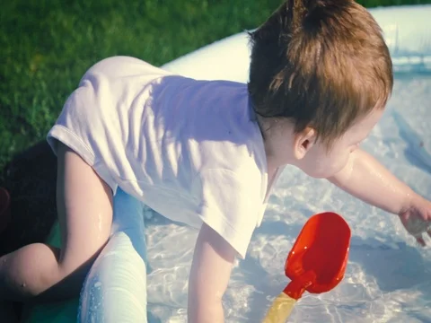 Baby boy plays in the pool Stock Footage 80607061