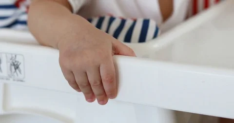 Baby boy small hand on white chair table Video stock 80963309