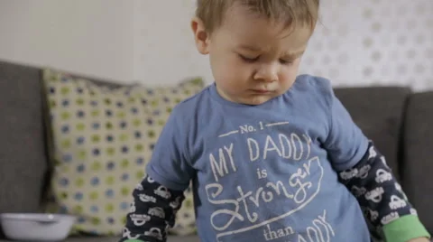 Baby boy stands in front of couch Stock Footage 44322475
