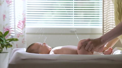 A baby boy suddenly starts to pee during... | Stock Video | Pond5