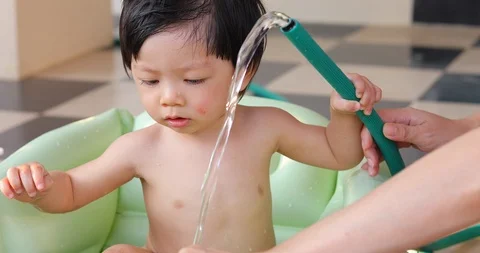 Baby boy take a bath in soft bathtub with mother Stock Footage 86405840