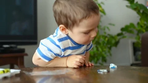 Baby boy talking while playing with plasticine at home Stock Footage 84096242