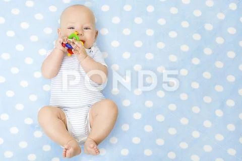 Baby Boy with Teether Toy In Mouth over Blue Background, Happy Infant Kid Boy Stock Photos
