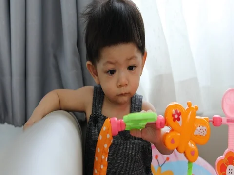 Baby boy using hand playing toy put in mouth Video stock 81790990