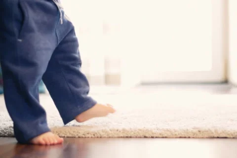 Baby boy walking his first steps, slow motion, dolly shot Stock Footage