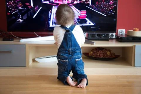 Baby boy watching TV at home Stock Photos