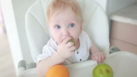 A baby breast eats a green apple 스톡 동영상 88880506