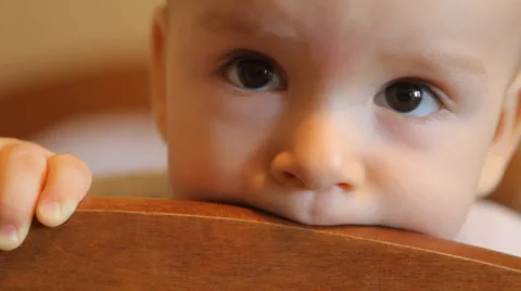 Baby chewing on the headboard Stock Footage 49604702