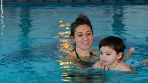 Baby child learn float pool mom teach swim familiar water Video stock 83808167