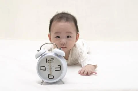 Baby with clock Stock Photos