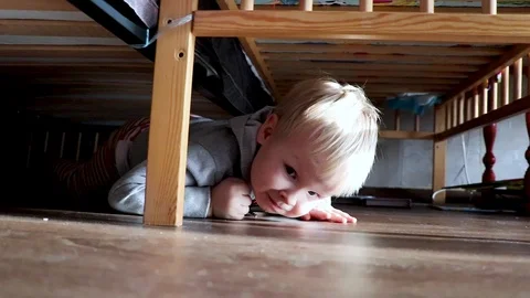 Baby crawling under the bed Stock Footage 100647438