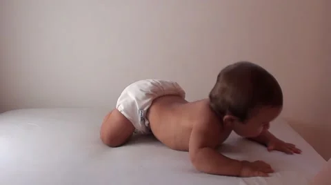 Baby crawls on the bed to the edge Stock Footage 40934310