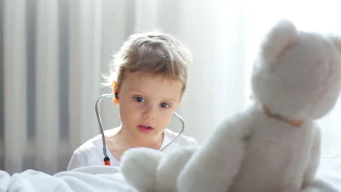 Baby with doctor's tools playing with teddy bear Stock Footage 87740180