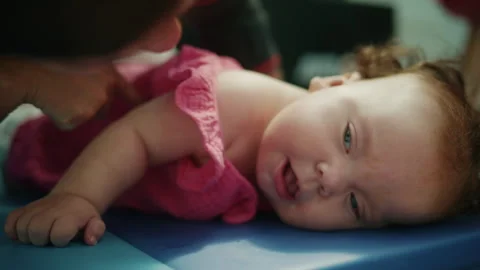 Baby with Down syndrome lying prone on a mat, working on early intervention and 스톡 동영상 343373403