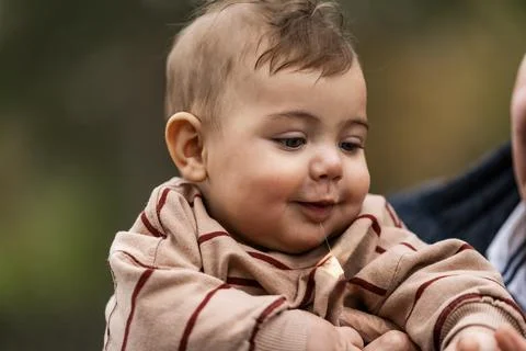 Baby drooling while being held by an adult Stock Photos