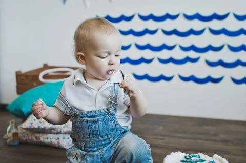 The baby eats cake with his hands 5566. Stock Photos