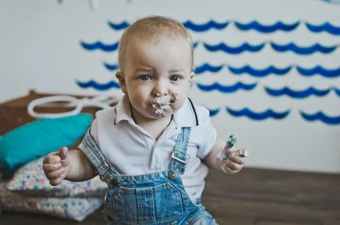 The baby eats cake with his hands 5568. Stock Photos
