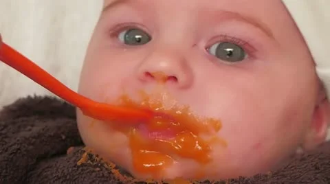 Baby eats carrot for the first time Stock Footage 11927285