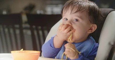 Baby Eats Handful of Pasta Medium Stock Footage 84767948