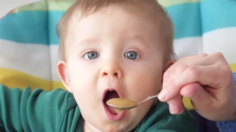 Baby eats puree from spoon, slow motion Stock Footage 88347387