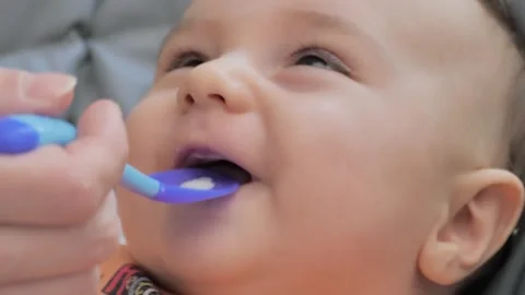 Baby eats from a spoon the first meal. Newborn's complementary feeding, fresh Stock Footage 241602624