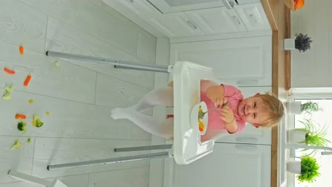Baby eats vegetables on a chair. Selective focus. Stock Footage 170143729