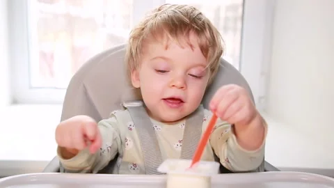 Baby eats yogurt Stock Footage 148742960