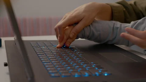 Baby explores typing on laptop while sitting with mother in home office Stock Footage 302912847