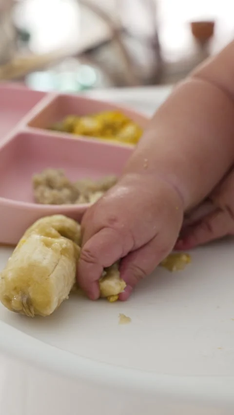 Baby Exploring Food Textures in Complementary Feeding with Banana Stock Footage 289350212