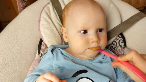 The baby is fed with a spoon. First complementary foods. Healthy food.Slow Stock Footage 239564764