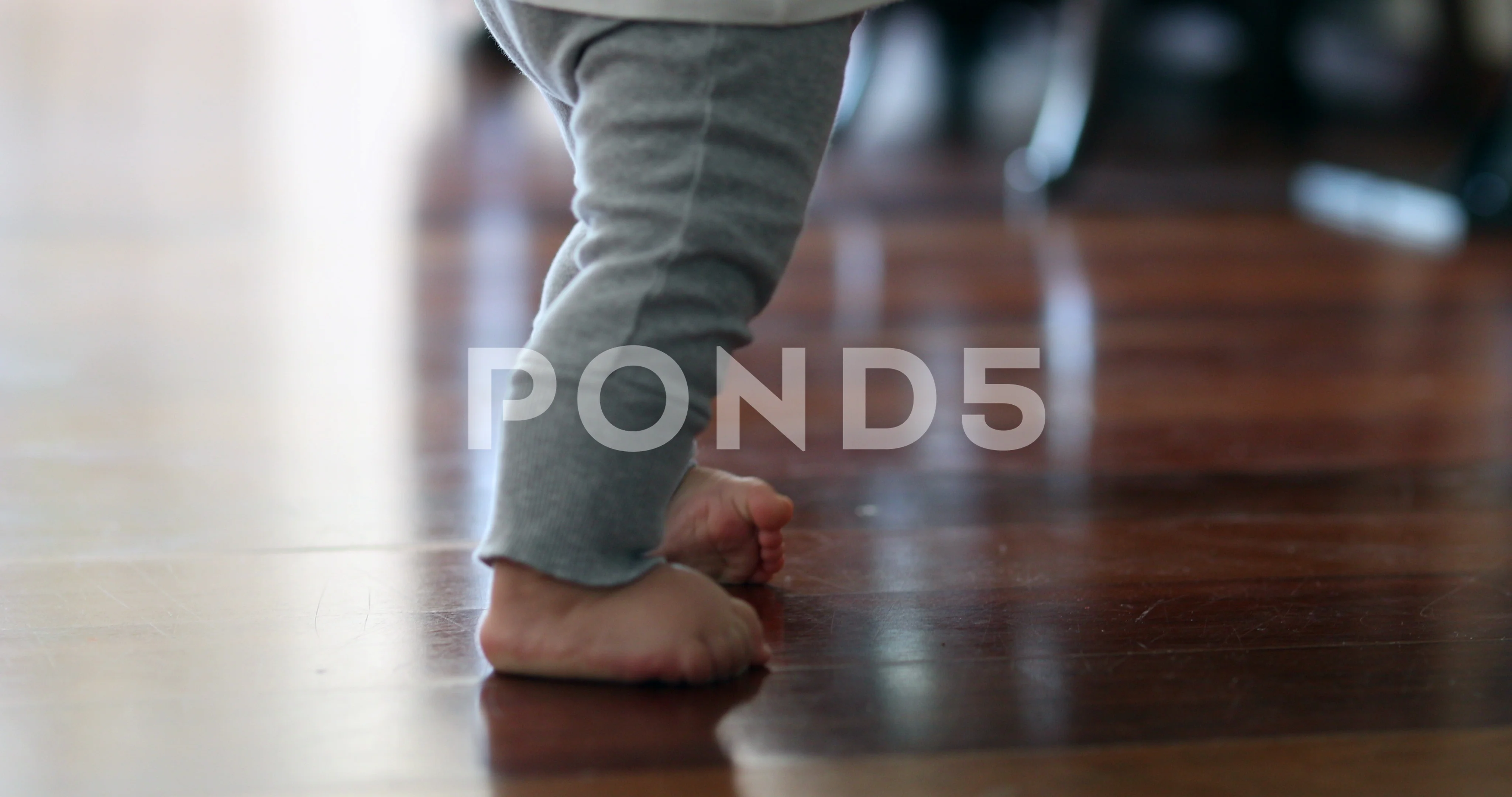 baby learning to walk on hardwood floors