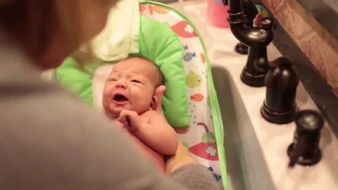 Baby First Bath at Home in Sink Stock Footage 85374557