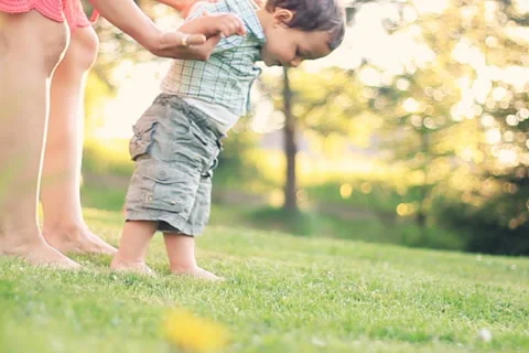 Baby first steps on grass, slow motion, dolly shot NTSC Stock Footage 5692874