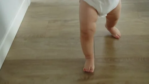 Baby First Steps Without Any Help, Close-Up Little Feet Walking On Floor At Home Stock Footage 170193830