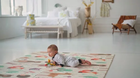 Baby first turn over exercise . Cute little baby turn on the belly on the mat Stockbeeldmateriaal 153330661
