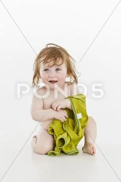 A Baby Girl Holding An Item Of Clothing