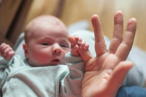 Baby girl holding mother finger. Grasping reflex of newborn Stock Photos