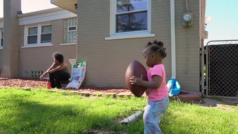 Baby girl playing with a football on a sunny day Stock Footage