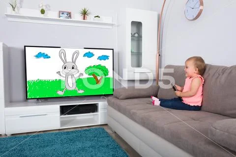 Baby Girl Watching Cartoon On Television Stock Photos