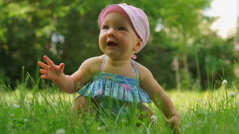 A baby on the grass for the first time rises to his feet Stock Footage 92156705