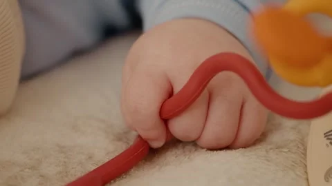 Baby hand close up playing with soft toys on a bed. Stock Footage 302452165